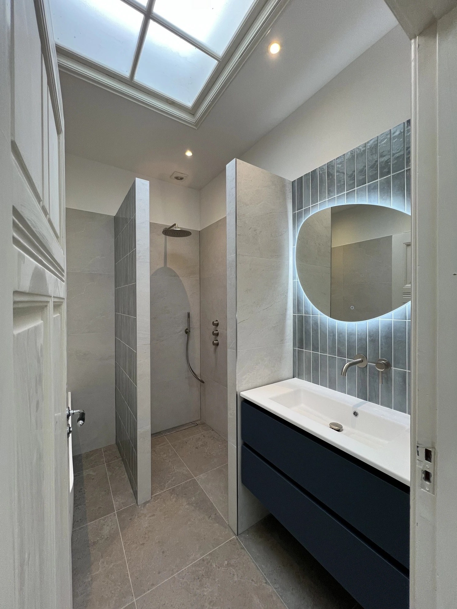 Badkamer met verlicht ronde spiegel