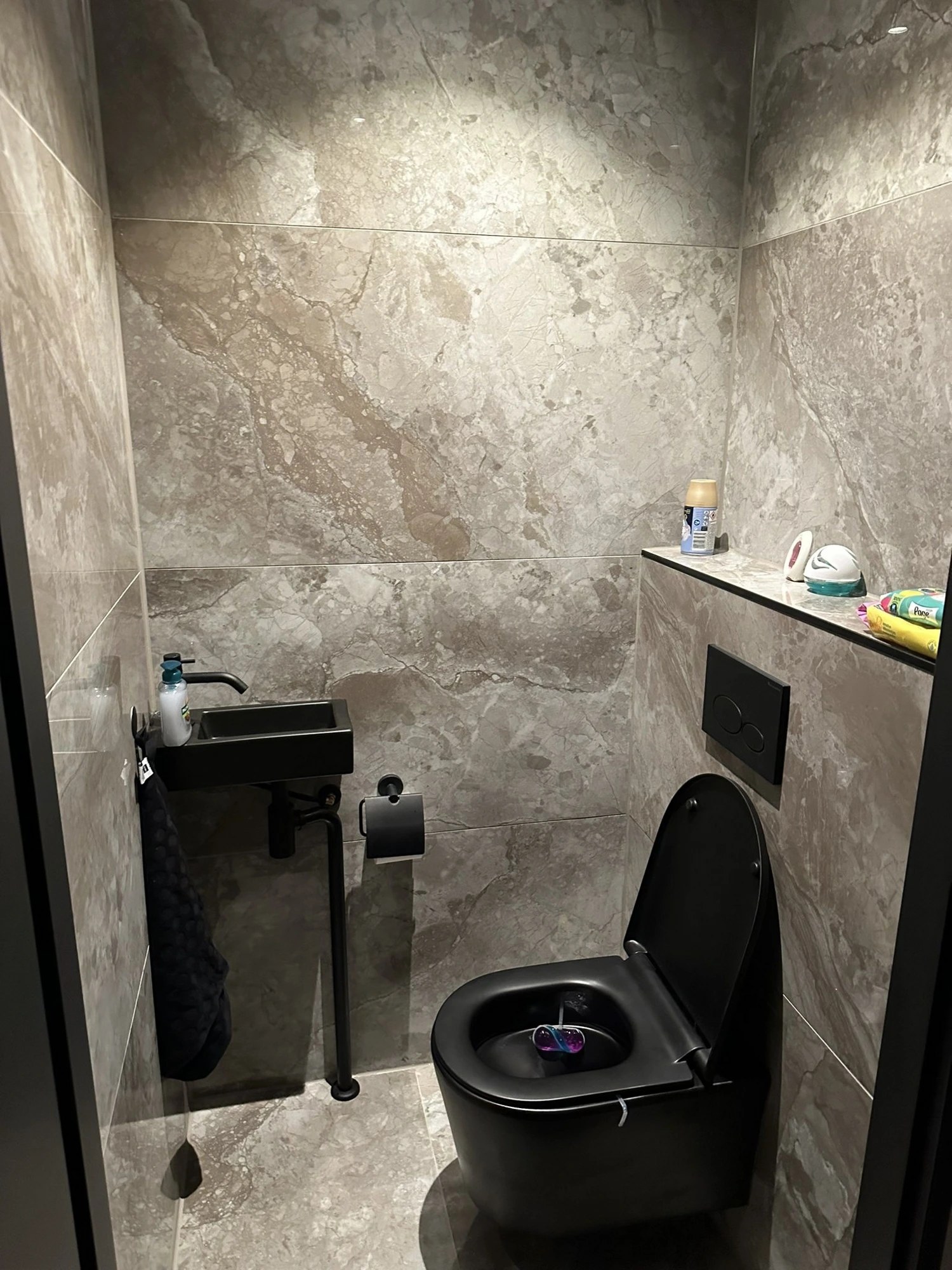 Toilet in marmerlook met zwart sanitair