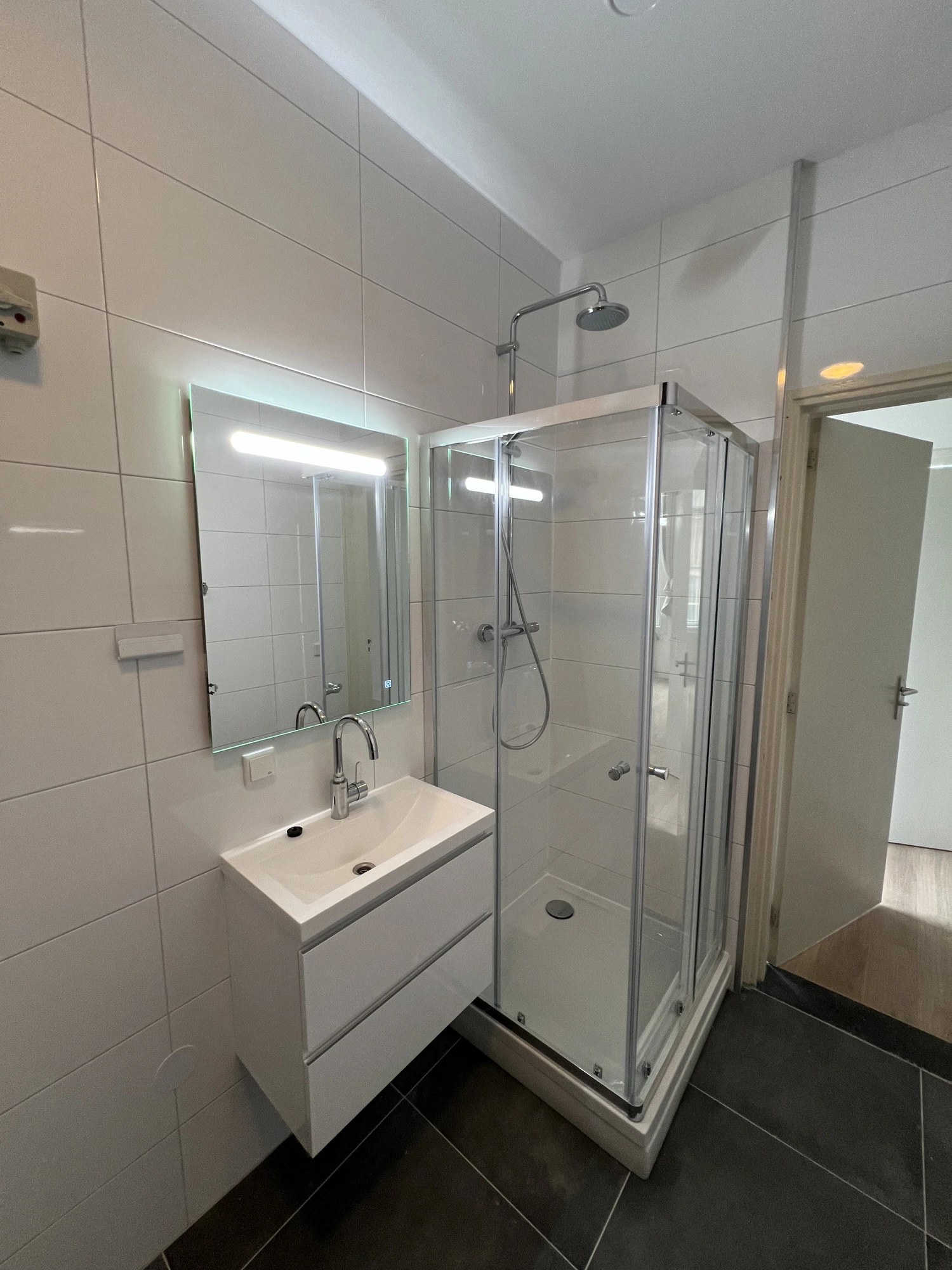 Witte badkamer met hoekdouche